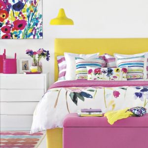Bright summer all white bedroom with floral print canvas on feature wall, matching bedding set, pink ottoman, vibrant yellow bed frame, matching aerial pendant lamp, white chest of drawers, patterned adele rug, IH, 07/2014, Pub Orig